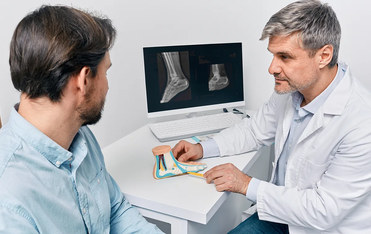 A foot and ankle surgeon reviewing an ankle X-ray with a patient