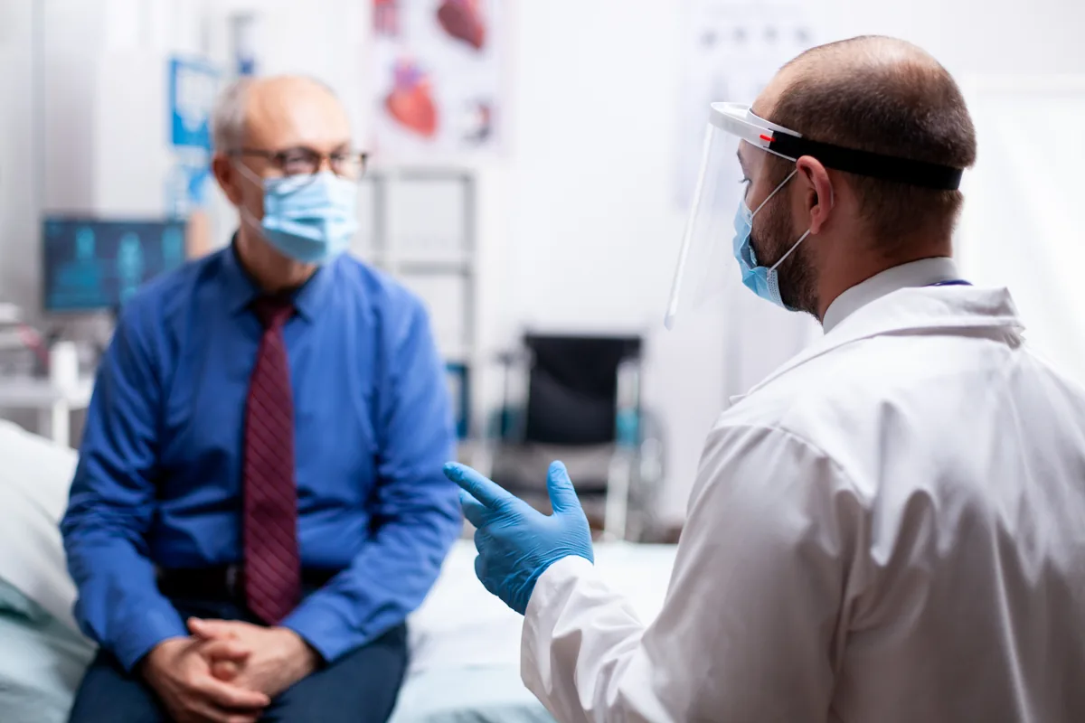 A general surgeon speaking with a patient before day surgery at an accredited private facility
