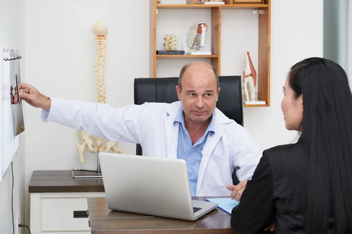 A general surgeon explaining hernia repair options to a patient