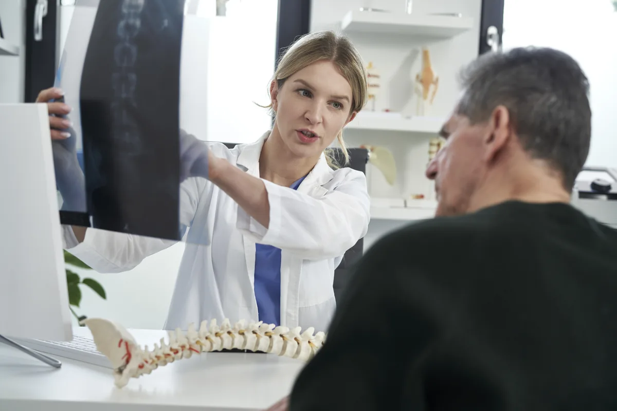 A spine surgeon reviewing a lumbar MRI showing a herniated disc
