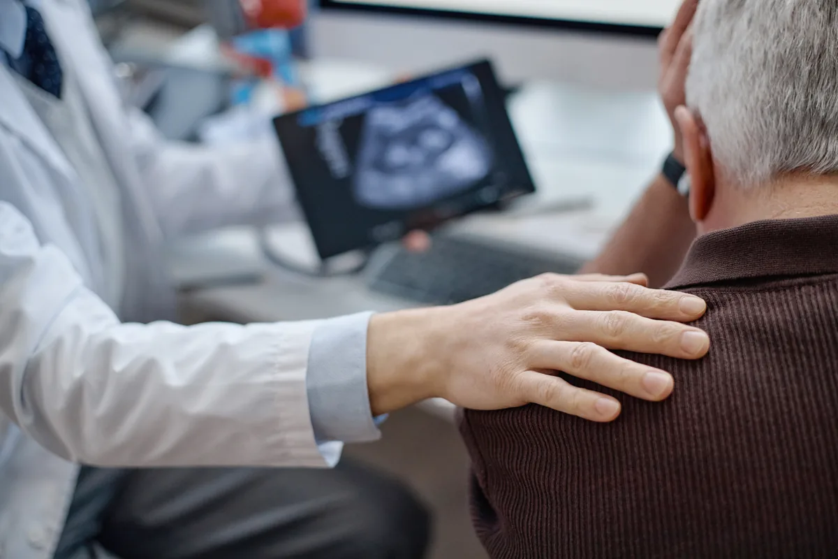 A shoulder surgeon reviewing a rotator cuff MRI with a patient